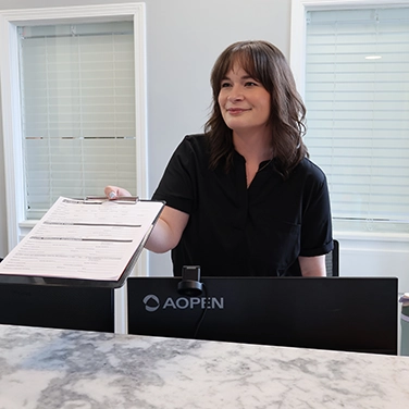 Peyton handing a patient paperwork.