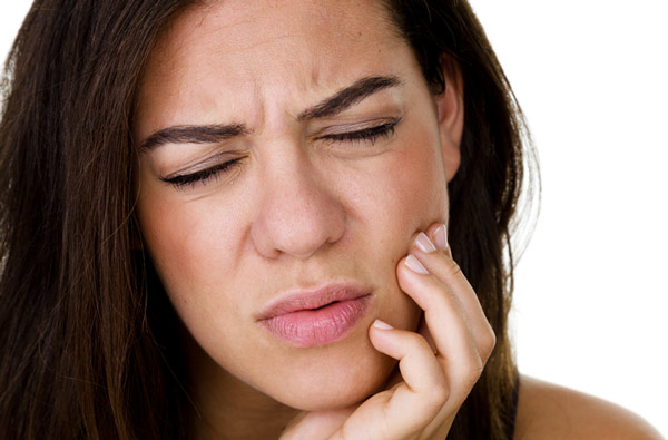 Woman holding jaw due to TMJ pain - before treatment at Singing River Dentistry in Russellville, AL